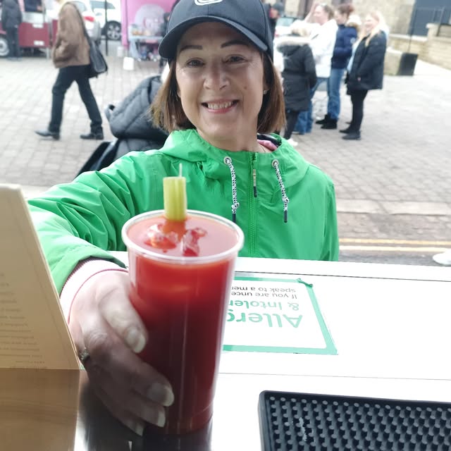 A Java John's barista with a fresh iced drink at an event