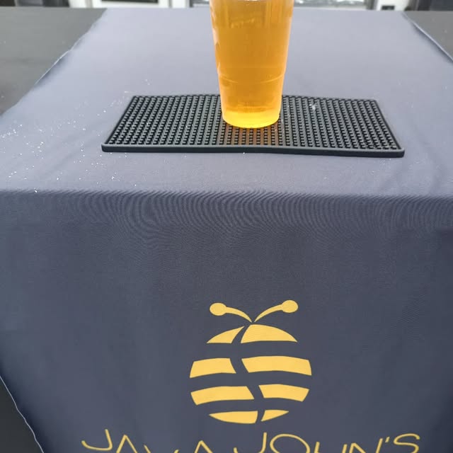 A fresh coffee on the Java John's counter with the bee logo
